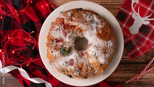 Photography Portuguese Bolo Rei is a traditional Chrismas cake with fruits and icing on wooden table