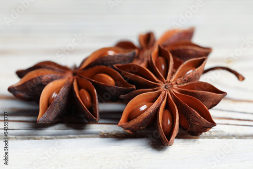 Aromatic anise stars on white wooden table, closeup
