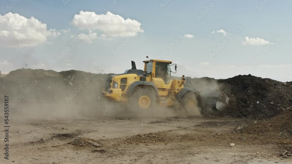Industrial compost production site. Tractors loading compost into screening machines and trucks. Slow motion Industrial compost production site. Tractors loading compost into screening machines and trucks. Slow motion