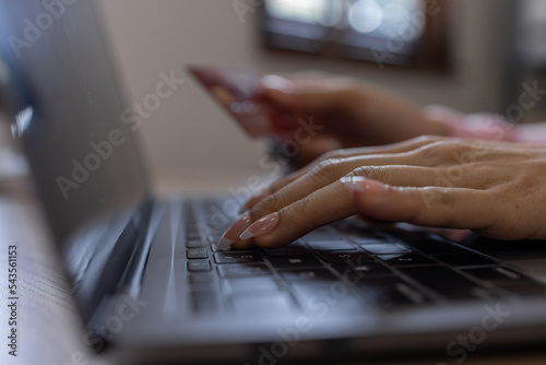 Asian woman hand using credit card and smartphone and laptop for buying online shopping payments