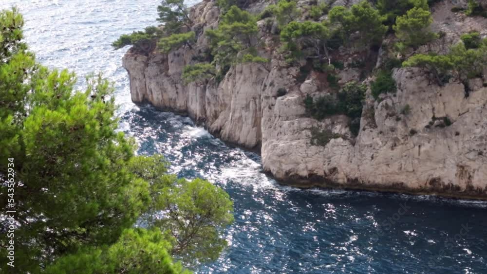 Beautiful view of a rocky bay with trees in the mediterranean sea and breaking waves with splashes on a summer day in the south of France, close-up side view in slow motion. Beautiful view of a rocky bay with trees in the mediterranean sea and breaking waves with splashes on a summer day in the south of France, close-up side view in slow motion.