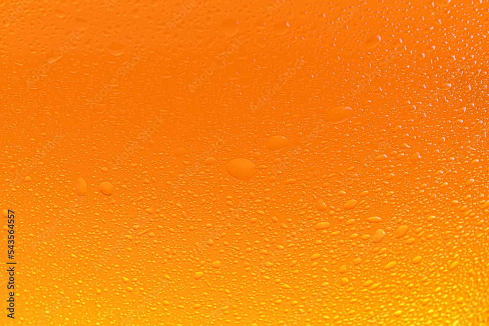 Glass of tasty cold beer with condensation drops as background, closeup