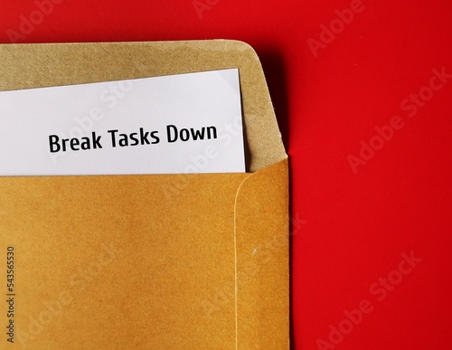 Document in office envelope with handwritten text note Break Tasks Down - means to break down tasks into smaller parts to make them easier to work on, focus on doing  just one work at a time photo