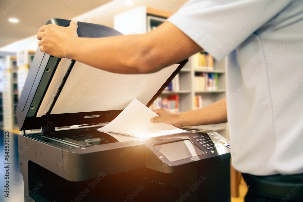Photocopier printer, Close up hand scanning paper on the copier or photocopy machine concept of office workplace scan document or printing or Xerox a sheet. - obrazy, fototapety, plakaty 