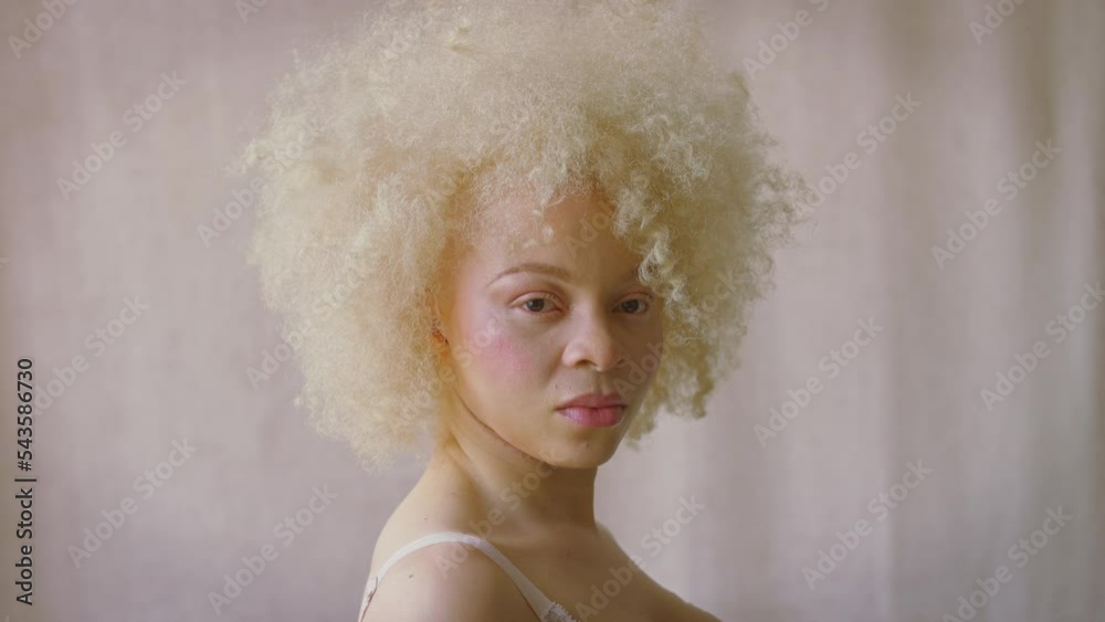 Studio shot of confident and positive young albino woman wearing underwear turning to look defiantly into camera - shot in slow motion Studio shot of confident and positive young albino woman wearing underwear turning to look defiantly into camera - shot in slow motion
