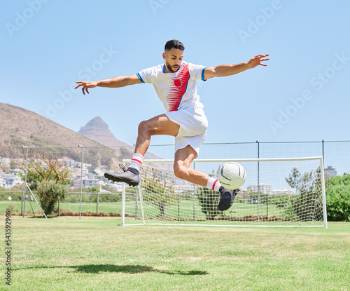 Soccer player field, man soccer ball trick and control outdoor on grass for sports, fitness and health. Jump football skill, young sport athlete and kick freestyle on pitch for wellness in Cape Town