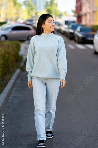 Happy young adult woman smiling with teeth smile outdoors and walking © speed300