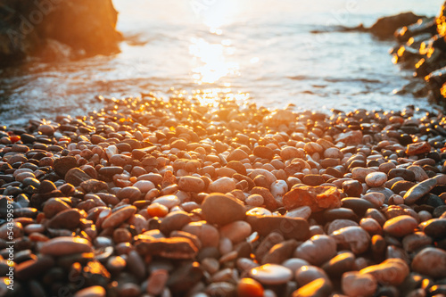 Pebbles on the beach. Summer Holiday in Croatia. beautiful Wallpaper. Gold orange colors. Warm sunset light. White edit space photo