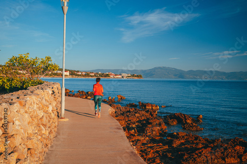 Runner on the beach of Malinska harbor and turquoise waterfront panoramic view  Krk island in Croatia