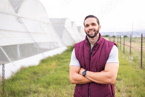 Farmer, greenhouse farm and portrait of happy man on firle outdoors. Young sustainability farming, eco friendly business owner and carbon capture lifestyle on agriculture countryside land in summer photo