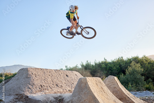 Bild auf Leinwand Nature, bike and cycling sports jump stunt on rocks ramp with fitness, training and exercise man
