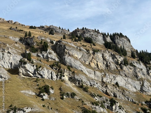 Steep stone cliffs and vertical rocks above the reservoir lake Panixersee (Lag da Pigniu) or Panixer Lake on the slopes of Glarus Alps mountain massif, Pigniu-Panix - Canton of Grisons, Switzerland photo
