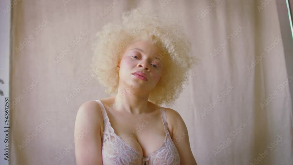 Studio shot of confident and positive young albino woman wearing underwear looking defiantly into camera - shot in slow motion Studio shot of confident and positive young albino woman wearing underwear looking defiantly into camera - shot in slow motion