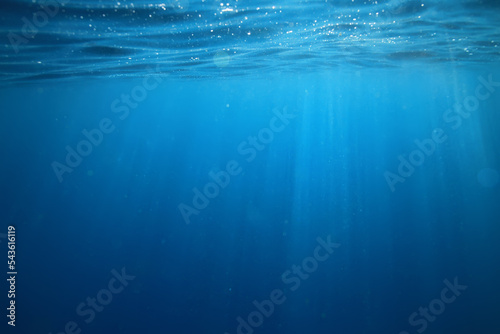 ocean underwater rays of light background, under blue water sunlight