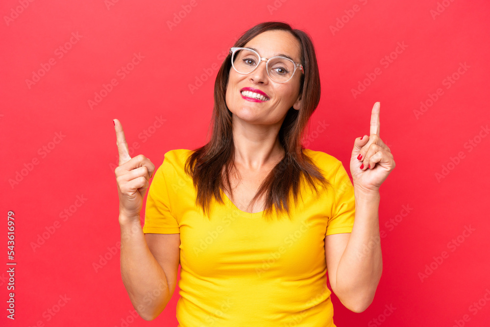 Middle-aged caucasian woman isolated on red background pointing up a great idea
