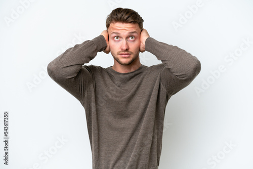 Young blonde caucasian man isolated on white background frustrated and covering ears © luismolinero