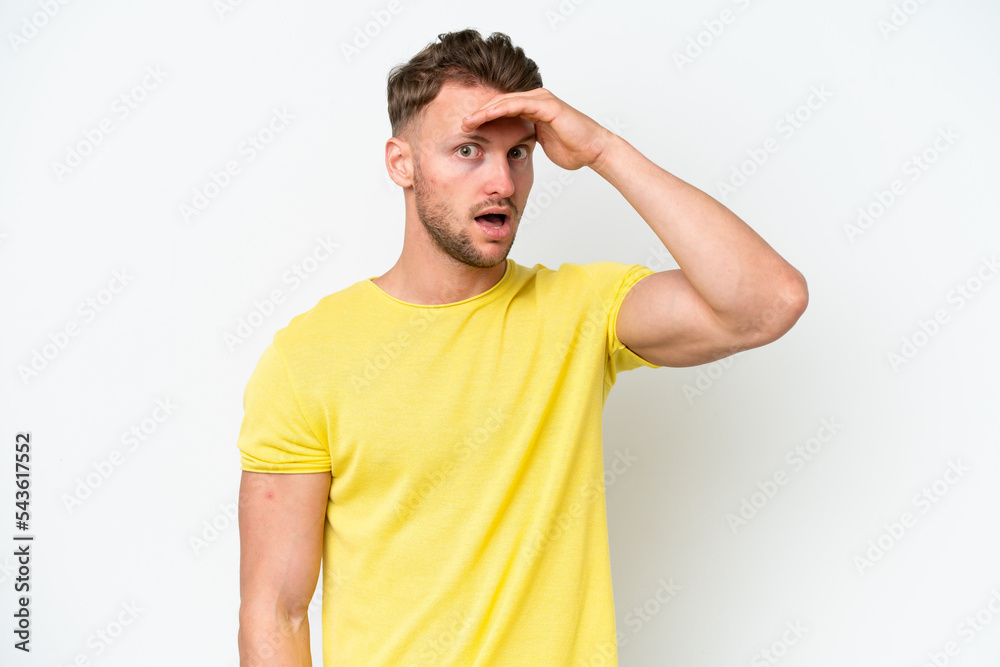 Young blonde caucasian man isolated on white background doing surprise gesture while looking to the side