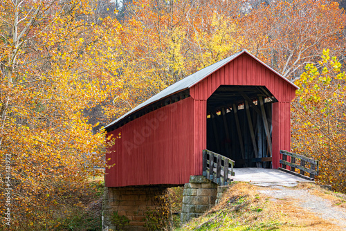 Foto Red covered bridge in bright fall foliage