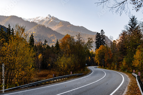 Beautiful winding autumn road through the trees against the backdrop of a large mountain. Caucasus, Dombay.
 photo