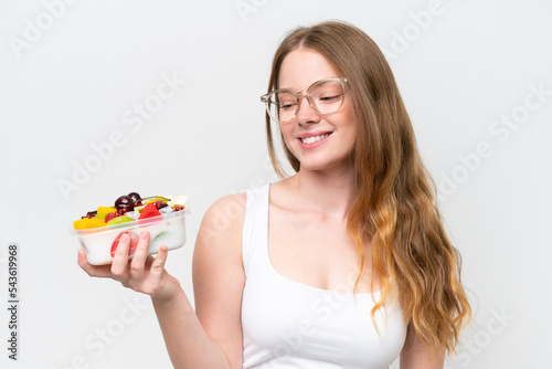 Young pretty woman holding a bowl of fruit isolated on white background with happy expression