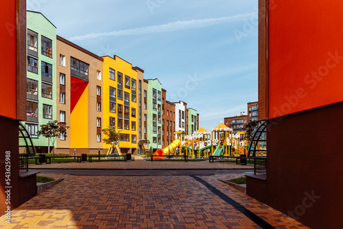 Children's playground in the courtyard of multi-storey residential buildings on a sunny day