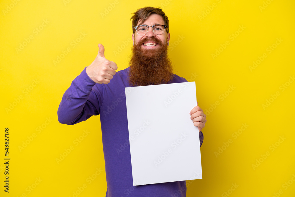 Redhead man with beard isolated on yellow background holding an empty placard with thumb up Redhead man with beard isolated on yellow background holding an empty placard with thumb up