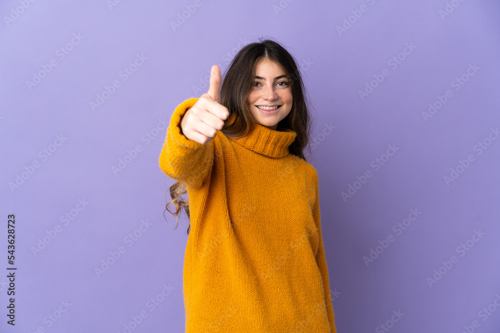 Young caucasian woman isolated on purple background with thumbs up because something good has happened Young caucasian woman isolated on purple background with thumbs up because something good has happened