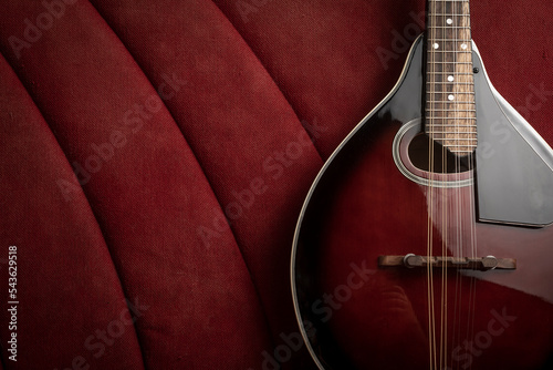 Background with mandolin leaning against a red sofa, plenty of room for text photo