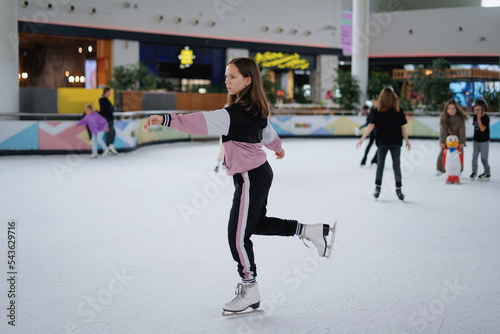 The girl is learning figure skating on ice