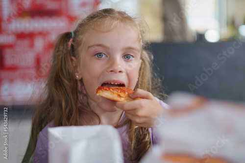 Curly blonde girl eating pizza