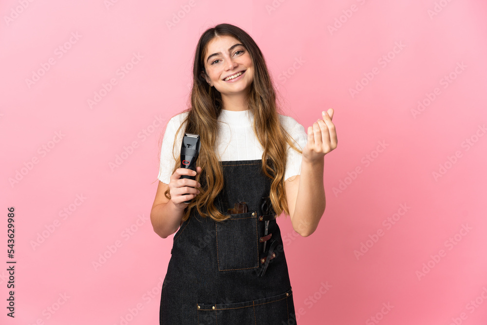 Young hairdresser woman isolated on pink background making money gesture Young hairdresser woman isolated on pink background making money gesture