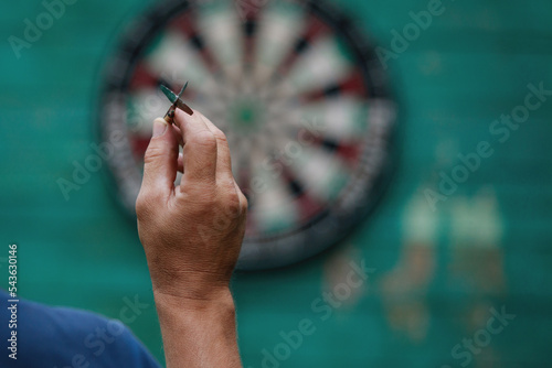 Hand with a dart for darts on the background of the target.