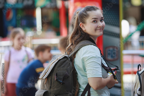 Young woman tourist with backpack smiling in summer park.