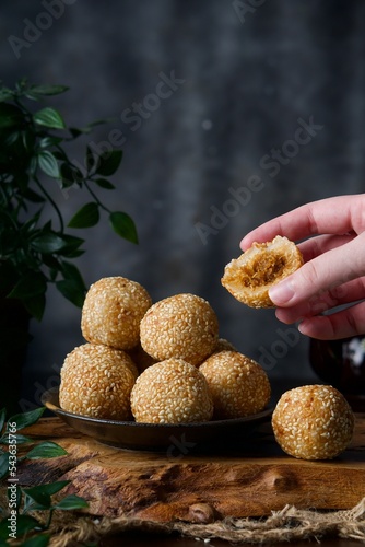 A very popular traditional Malaysian dessert. Also called a kuih bom. Sweet coconut inside. A woman's hand takes the dessert