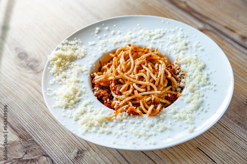 delicious spaghetti with tomato sauce on wooden table background, close up