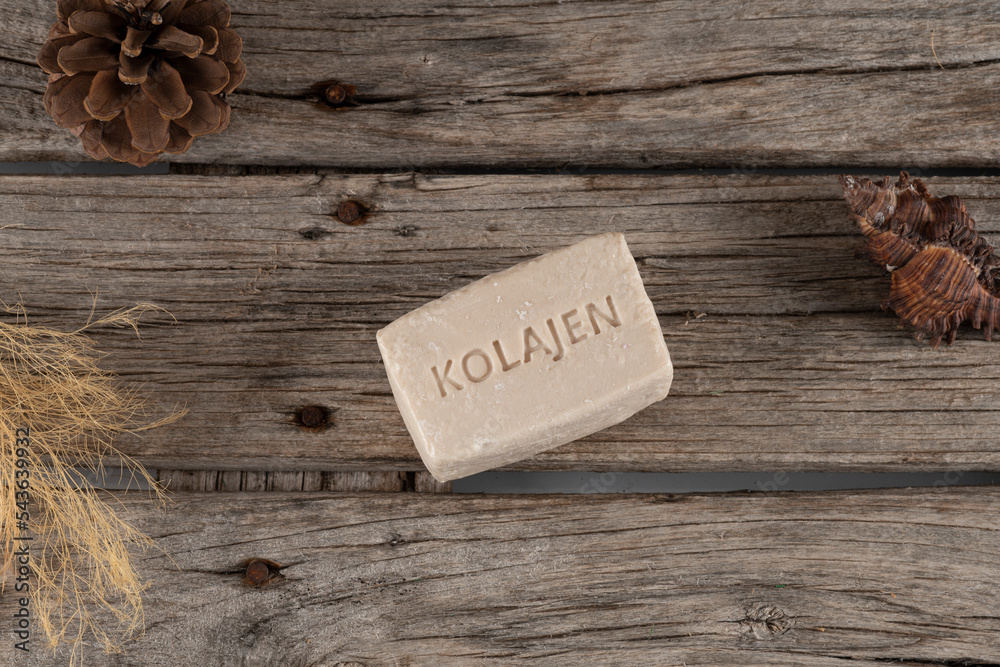 Naklejka premium natural collagen soaps made with donkey milk stil life photo. on wooden background and soap, soap with collagen written on it