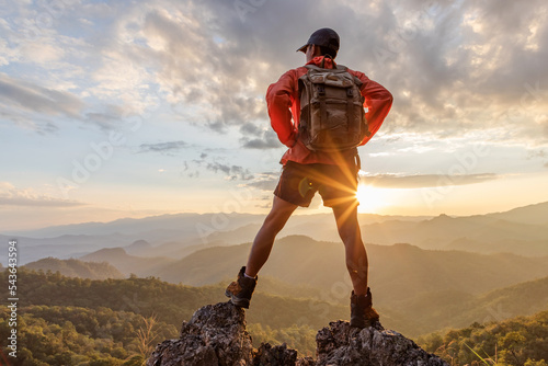 Male hiker with backpack relaxing on top mountain landscape enjoy beautiful landscape view sunset.