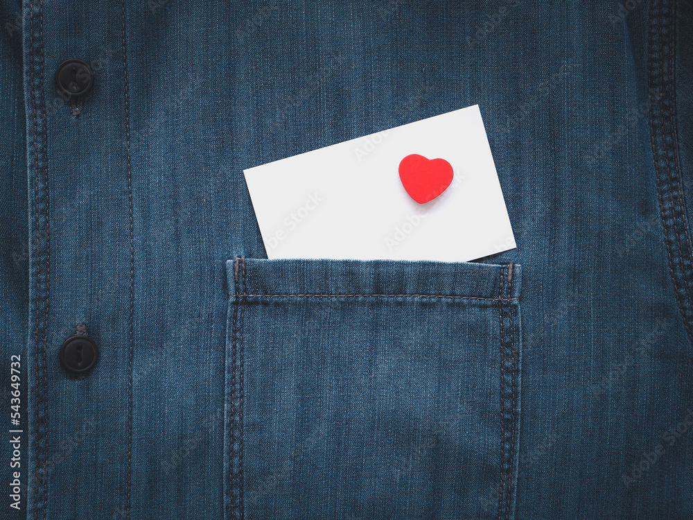 Blank white card and red hearts in a jeans shirt pocket. Close-up, space for text. .