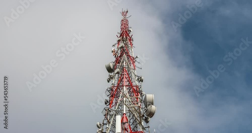Transmission tower against fast moving clouds and blue sky