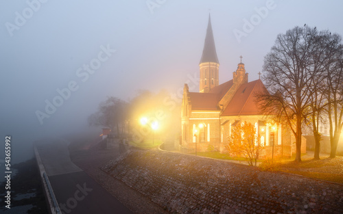 Kaunas, Lithuania 11-04-2022 Amazing church in fog. Vytautas church in Kaunas city Nemunas river. Big autumn morning, mystic fogy morning. Travel Lithuania, amazing country. Stunning view, fog calm. photo