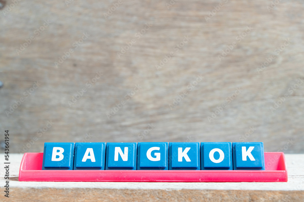 Tile alphabet letter with word bangkok in red color rack on wood background