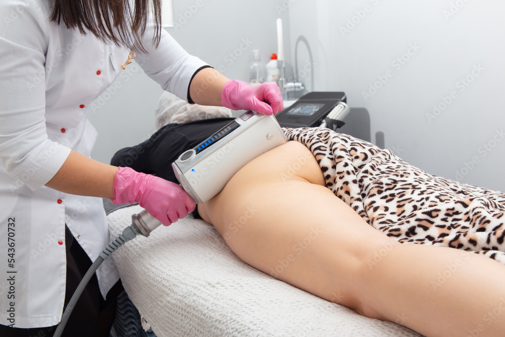 The masseur does a massage using anti-cellulite massage machine with compression and vibration technology in beautician office. Endermologie is the only FDA-approved and non-invasive method 