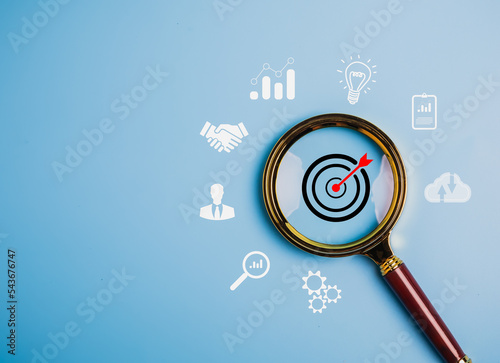Magnifier glass focus to target dartboard, Business development strategy and action plan concept with icon business strategy and Action plan, search, goal, strategy, success