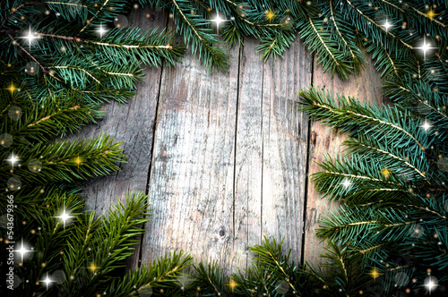 Christmas (New Year) decoration composition. Top view of fur-tree branches, cones and stars on wooden background with place for your text