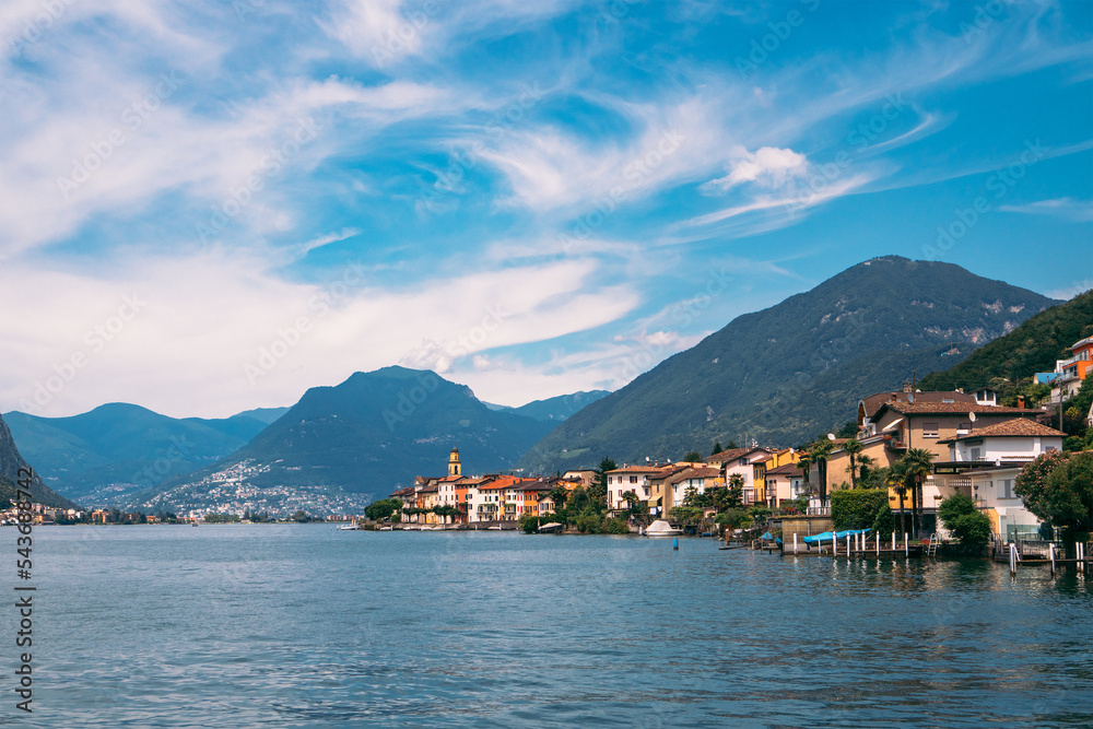 Panoramic view of Brusino Arsizio, located at the foot of Monte San Giorgio, on the shores of Lake Lugano, canton of Ticino, Switzerland. Beautiful landscape of the lake, Alps and lakeside villas.