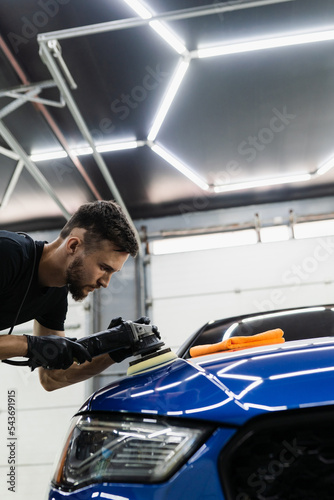 Car polishing with orbital polisher for remove scratches. Worker of detailing auto service making final polishing for car. © Rabizo Anatolii