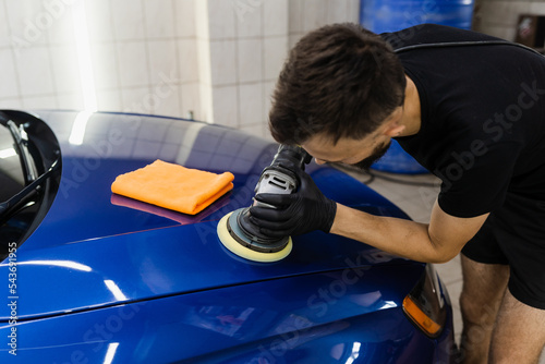 Abrasive paste car polishing with orbital polisher for remove scratches. Worker of detailing auto service making final polishing for car. photo