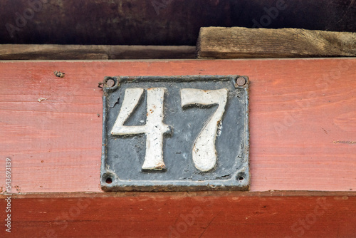 Old retro weathered cast iron plate with number 47 closeup