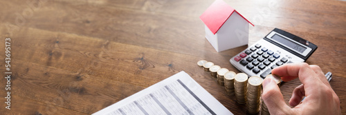 Person Stacking Coins On Wooden Desk