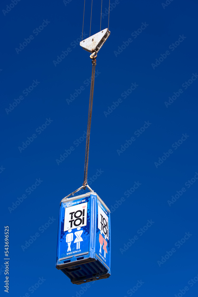 Transporting mobile toilet at highway enclosure construction site at